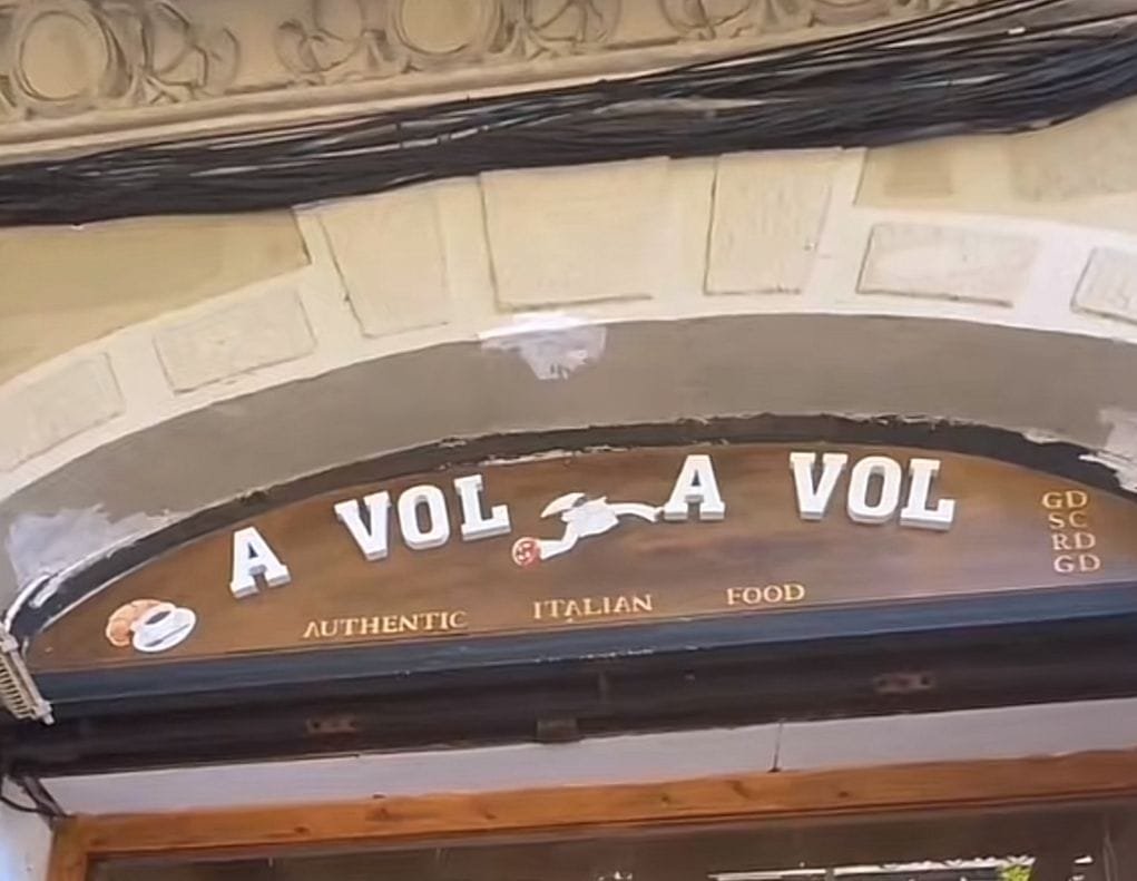 Restaurante de comida italiana, la entrada tiene forma de arco y en la parte superior encontramos unas letras sobre una base de madera con un marco metálico. Las letras son de una tipografía un tanto informal pero el texto aparenta ser formal por el uso de mayúsculas, las de color blanco contrastan con el color café de fondo, resaltando así el nombre, en letras pequeñas se ve “Authentic Italian Food” de un color beige. El diseño arquitectónico del establecimiento resalta de una manera peculiar, pues es utilizado desde hace ya algunos años, llenos de historia, haciendo honor a la cultura española.