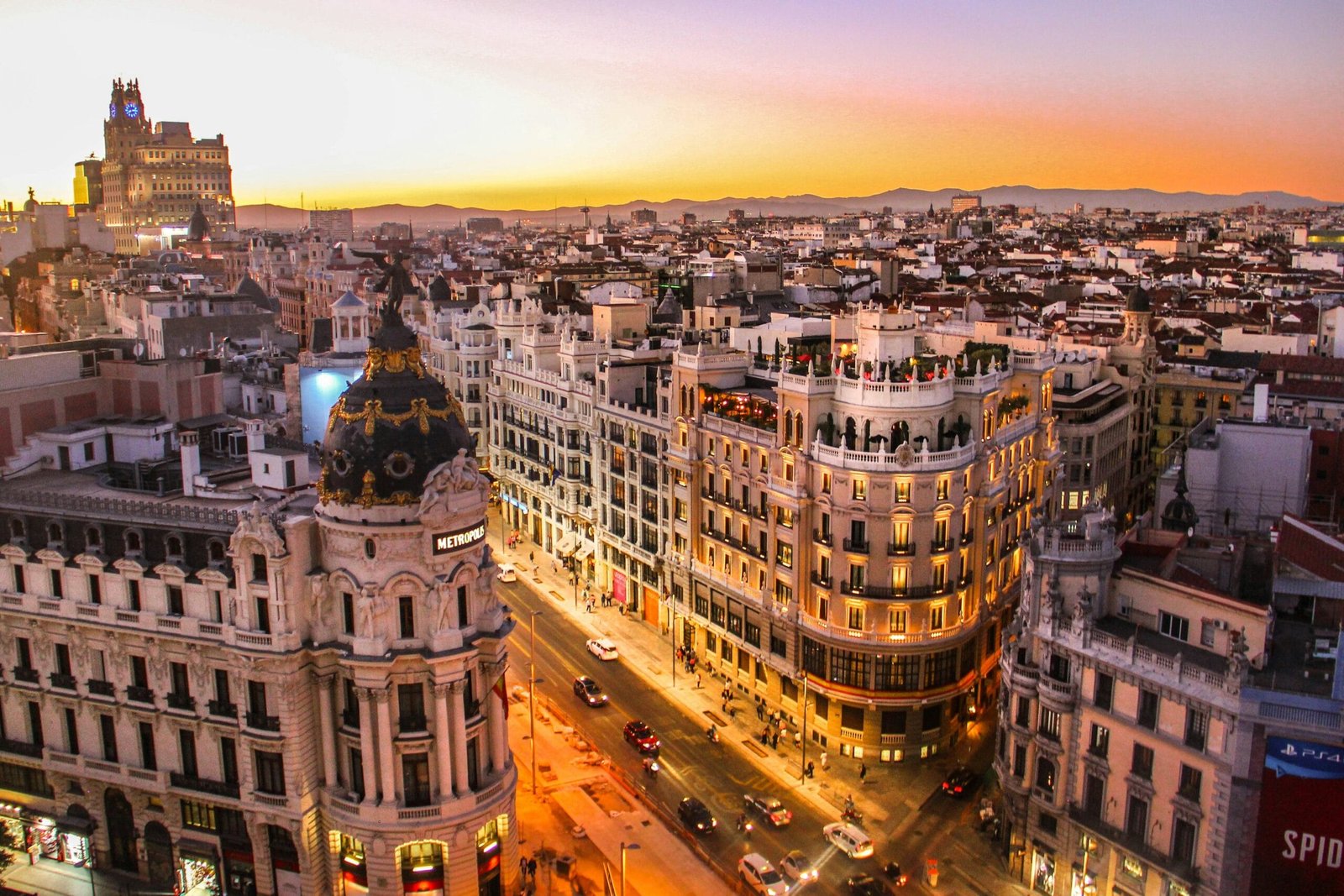 Avenida histórica que atraviesa el centro de la ciudad. Su construcción resalta una gran obra de ingeniería para su época. Rodeado de tiendas de moda, restaurantes, grandes cadenas internacionales y centros comerciales. Destacan edificios icónicos llenos de historia. Es un lugar lleno de vida madrileña y transporte por todos lados. Se aprecian luces, personas, terrazas, y el ambiente de una ciudad que nunca se detiene, lo cual la hace una de las ciudades más bonitas de Europa.