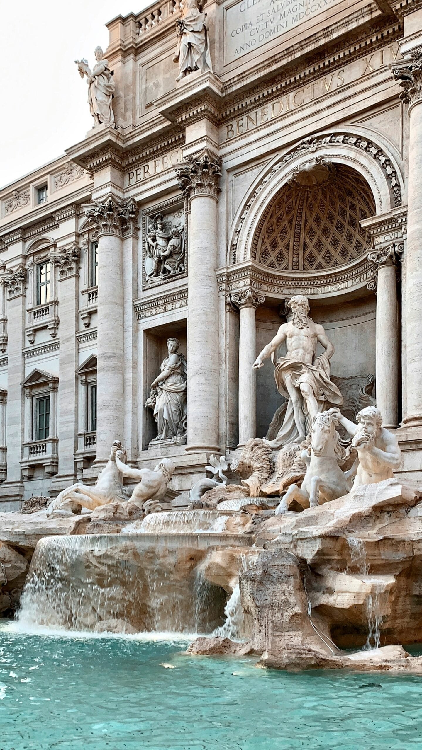 Increíble lugar de historia, hay una fuente con una fachada de estilo barroco imponente. En el centro de la fuente hay un gran arco con columnas, que simulan la entrada a un templo clásico. Dentro del arco principal, se encuentra Neptuno, dios del mar, montado en un carro con forma de concha. Neptuno está acompañado por dos tritones (criaturas mitológicas mitad hombre, mitad pez). Cada tritón lleva un caballo marino: uno salvaje y otro tranquilo. A los lados de Neptuno hay dos grandes estatuas que representan la Abundancia, que derrama agua de una jarra y la Salubridad, que sostiene una copa de la cual bebe una serpiente. El agua cae en una gran piscina de forma irregular, de un azul verdoso muy claro, que contrasta con la piedra clara del monumento. Siempre hay gente alrededor, lanzando monedas de espaldas al agua como tradición y costumbre, para asegurarse el regreso a una de las mejores ciudades, Roma.