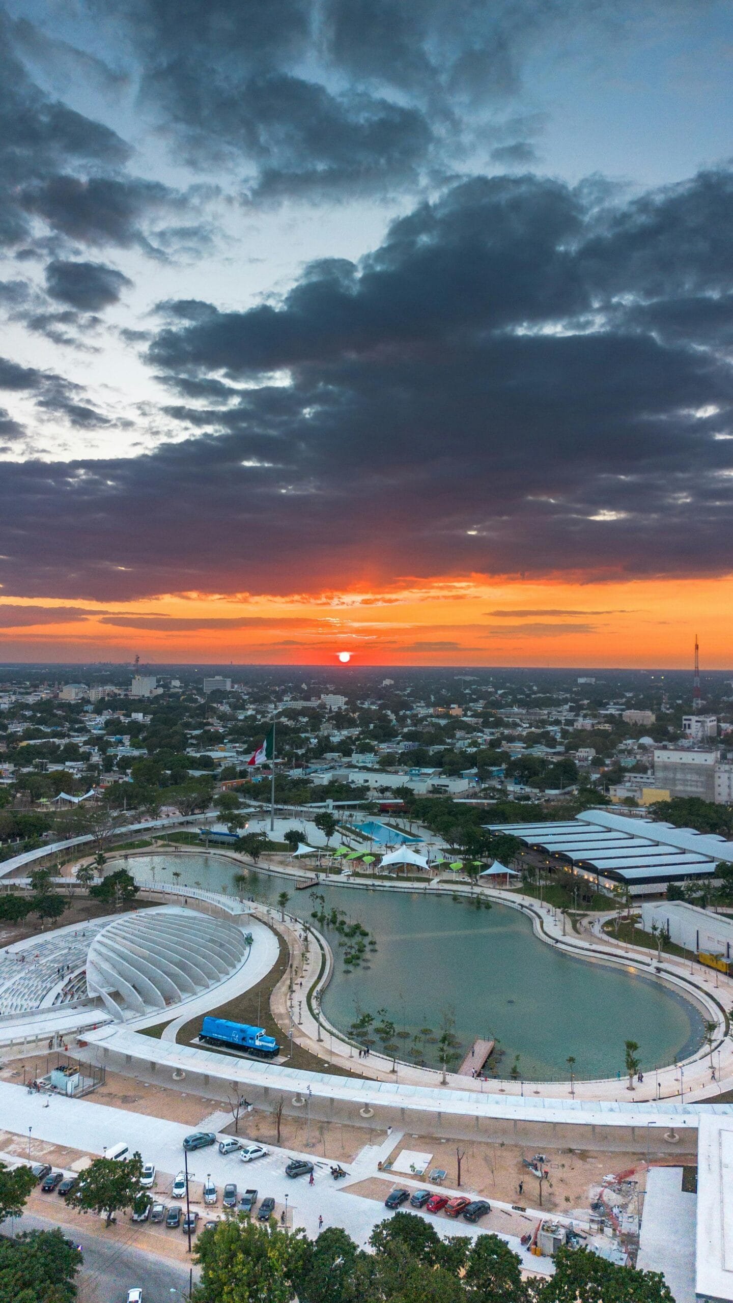 Mérida en México, dónde está uno de Los mejores restaurantes de América, se aprecia desde una vista aérea un atardecer y una gran parte de la ciudad con una laguna enmedio.